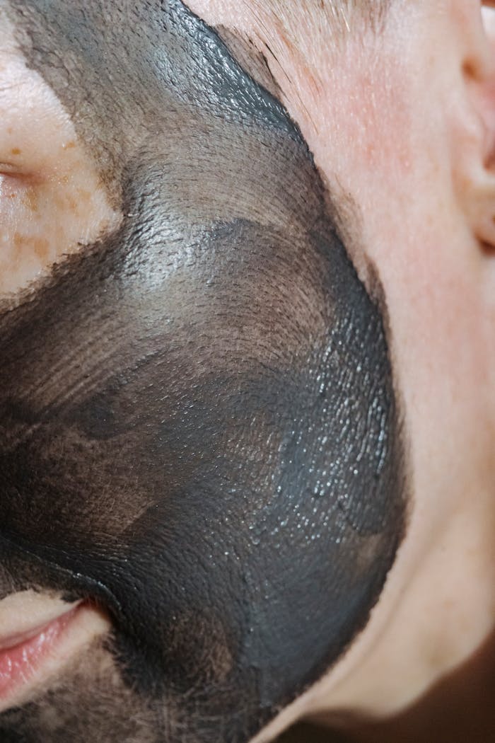 Extreme close-up of a persons face with a black clay mask for skincare treatment.